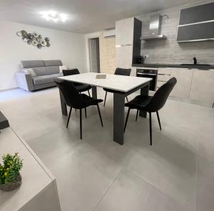 a kitchen and dining room with a table and chairs at APPARTAMENTO PICASSO in Villasimius