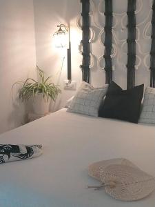 a bedroom with a white bed with a black headboard at Ishel Trafalgar in Zahora