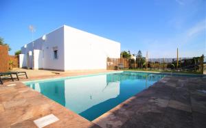 a swimming pool in front of a white building at Ishel Trafalgar in Zahora