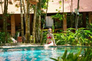 富國的住宿－Valley Village Phu Quoc，坐在游泳池里的比基尼女人