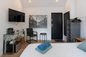 - une chambre avec un lit, un bureau et une chaise dans l'établissement Raam Studio's, à Amsterdam