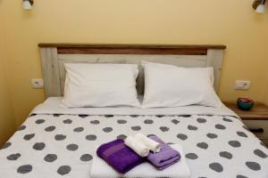 a bed with two towels and pillows on it at Sunset Apartments in Kotor