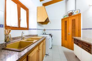 a kitchen with a sink and a stove at Petita Casa Marinero in Portopetro