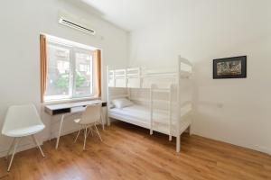 Sleep Hostel في نيشْ: غرفة نوم بسريرين بطابقين ومكتب ونافذة