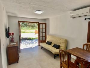 a living room with a couch and a table at Agradable casa rural en zona reserva natural. in Sant Francesc Xavier