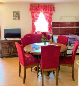a dining room with a table and red chairs at Home in Banja Luka- Vikendica za iznajmljivanje in Banja Luka