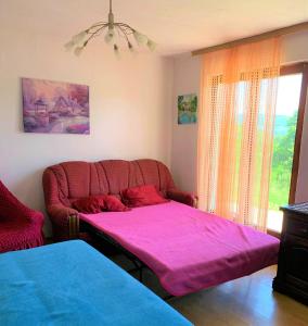 a living room with a couch and a pink blanket at Home in Banja Luka- Vikendica za iznajmljivanje in Banja Luka