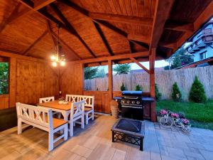 a screened in porch with a table and a stove at Apartamenty Kolorowa in Szczyrk