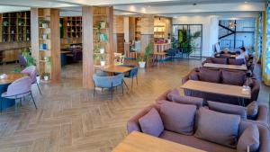 博斯特里Olimp Hotel的有沙发、桌椅的餐厅