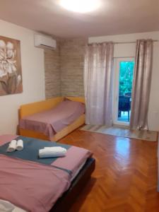 a small bedroom with two beds and a window at Muring Apartments in Tribunj