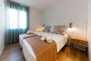1 dormitorio con 2 camas y ventana en Bravissimo Tarlà, 2-bedroom apartment, en Girona