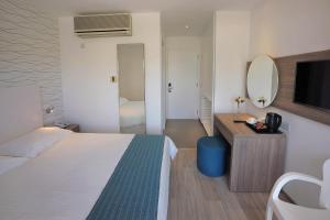 a hotel room with a bed and a mirror at Okeanos Beach Boutique Hotel in Ayia Napa