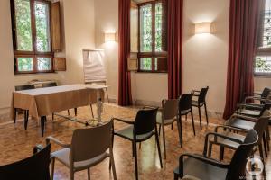 Habitación con mesa, sillas y ventanas. en Hotel Casa Valdese Roma en Roma