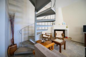 a living room with a spiral staircase and a table at Avramio Village Maisonette in Avramión