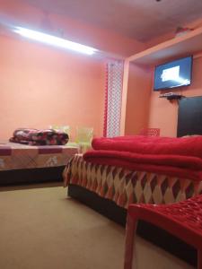 a bedroom with two beds and a flat screen tv at Badri Kedar Hometay in Joshīmath