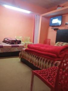 a room with two beds and a flat screen tv at Badri Kedar Hometay in Joshīmath