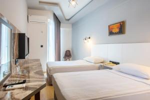 Postel nebo postele na pokoji v ubytování Aslan Sand & City Hotel