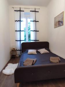 - un lit avec des draps bleus dans une chambre avec une fenêtre dans l'établissement Apartment Tina, à Pula