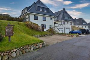 a large white house with a sign in front of it at Westcoast in Hörnum