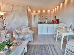 a living room with couches and a table and a kitchen at Sylt Cottage in Morsum