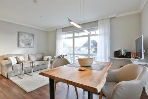 ein Wohnzimmer mit Tisch und Couch in der Unterkunft Sylt Beach in Wenningstedt-Braderup