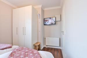 1 Schlafzimmer mit 2 Betten und einem TV an der Wand in der Unterkunft Sylt Beach in Wenningstedt-Braderup