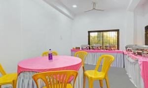 a room with pink and yellow tables and chairs at Treebo Trend Villa Inn Aurangabad in Aurangabad