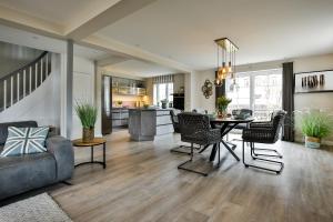 a living room with a table and chairs and a kitchen at Stjerna Hues in Hörnum