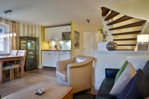 a kitchen and living room with a spiral staircase at Duenenperle in Rantum