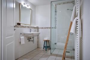 a bathroom with a glass shower and a sink at Duenenperle in Rantum