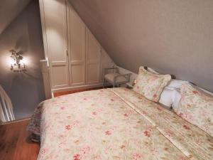 a bedroom with a bed with a floral bedspread and pillows at Fernsicht in Morsum