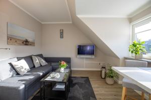 a living room with a couch and a tv at Sylt Like in Tinnum