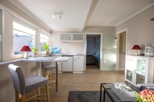 a kitchen and living room with a table and chairs at Sylt Like in Tinnum