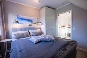 a bedroom with a large bed with a blue comforter at Sylt Like in Tinnum
