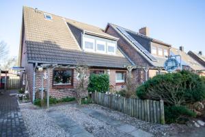 a brick house with a fence in front of it at Sylt Like in Tinnum