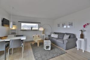 - un salon avec un canapé et une table dans l'établissement Strandhaus, à Hörnum