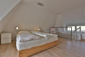 a bedroom with a bed with a wooden floor at Strandhaus in Hörnum