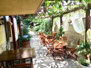 オブゾルにあるFamily Hotel DAFの木製のテーブルと椅子、植物のあるパティオ