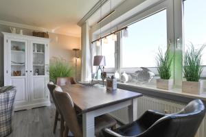 a dining room with a table and chairs and a window at Strand und Meer in Hörnum