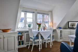 a dining room with a table and chairs and a window at Snetjers Hüs Appartement 13 in Hörnum