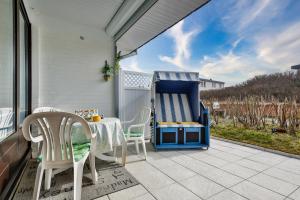 a patio with a table and chairs and a large blue and white object at Kniepsand in Hörnum +6 photos