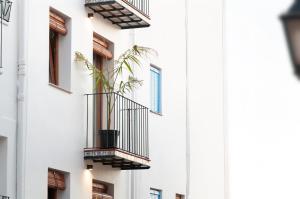 - un bâtiment blanc avec un balcon et une plante dans l'établissement Boho Apartments, à Peñíscola