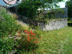 a garden with a stone wall and flowers at la petite maison d'Albert in La Motte-Saint-Jean