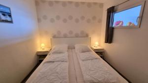 - une petite chambre avec un lit et 2 tables de chevet dans l'établissement Ferienpark F12-004 Ferienpark, à Heiligenhafen