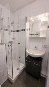La salle de bains est pourvue d'une douche en verre et d'un lavabo. dans l'établissement Ferienpark F12-004 Ferienpark, à Heiligenhafen