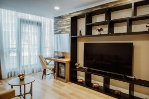 ein Wohnzimmer mit einem großen TV und einem Tisch in der Unterkunft King Solomon Batumi Hotel in Batumi