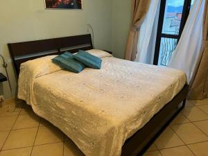 a bedroom with a bed with two blue pillows on it at Eco del ponte in Sasso di Castalda