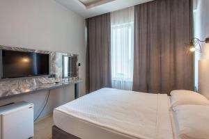 TV a/nebo společenská místnost v ubytování Aslan Sand & City Hotel
