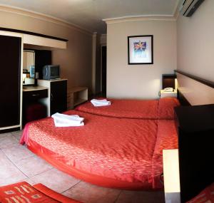 a hotel room with a bed with red sheets at HİMEROS BEACH HOTEL in Kemer +28 photos