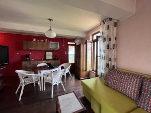 a living room with a yellow couch and a table at BRUNETTE BEAUTIES Guesthouse & Studio Sinemorets in Sinemorets